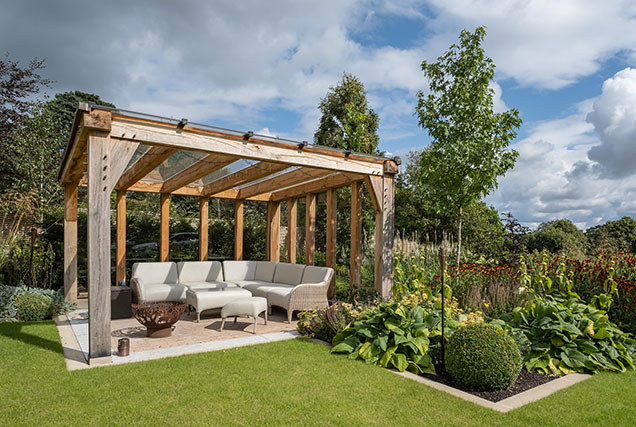 an outdoor lounge area sitting under an Oak Pergola