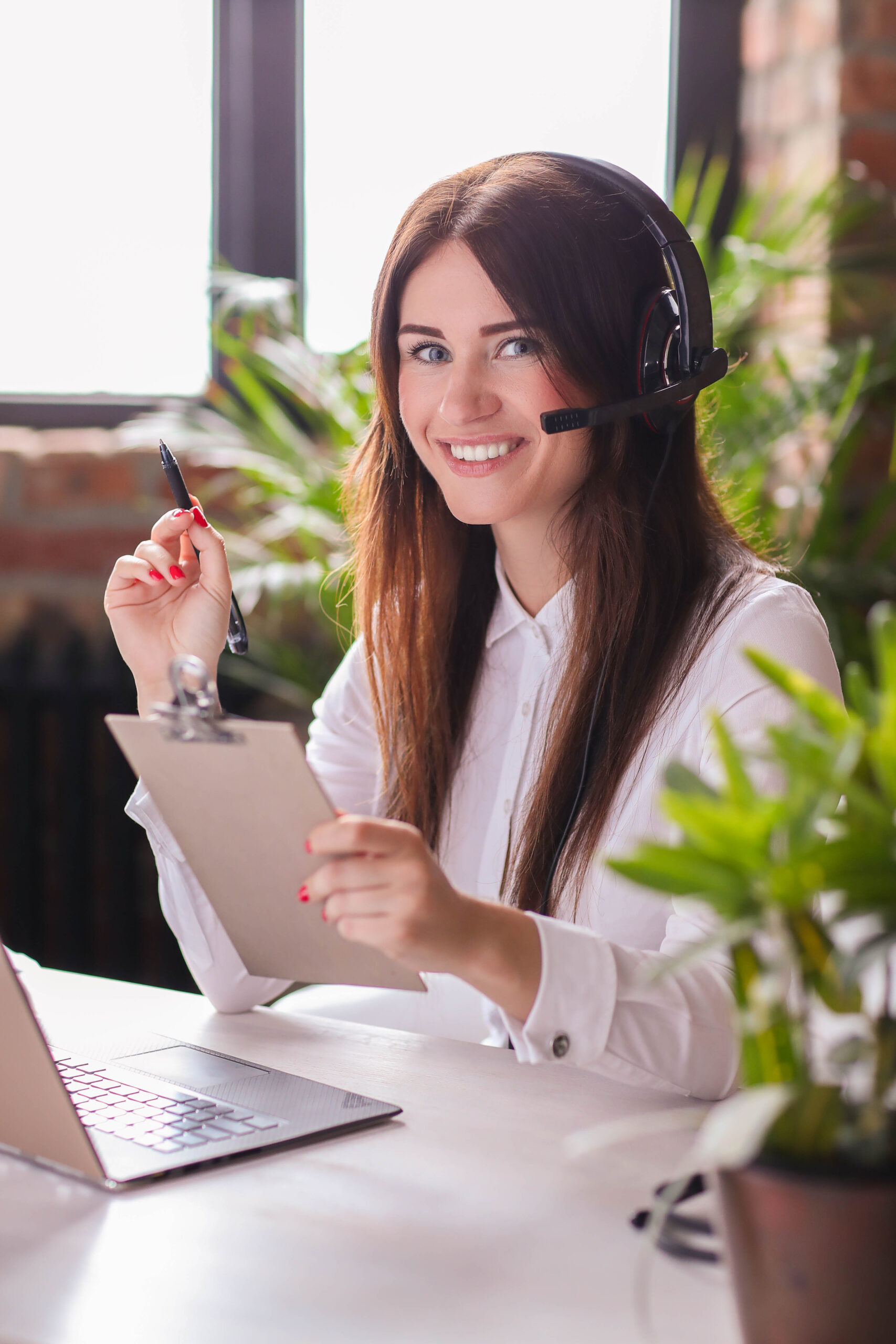 Women on the phone holding a clipboard in an office.